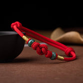 Red String and Lucky Jade Bead Bracelet, a meaningful charm bracelet for good luck, protection, and positive energy.